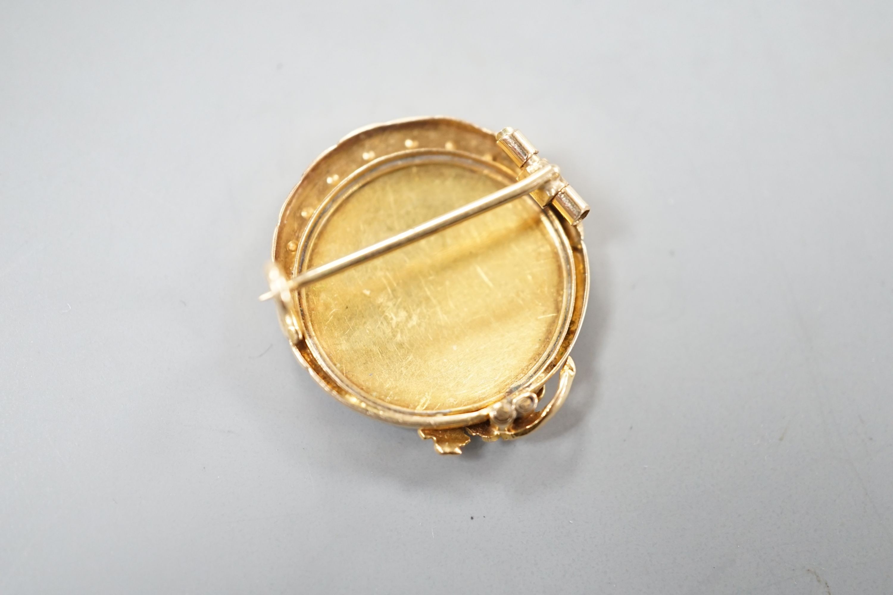 A nearly 20th century yellow metal, blue enamel and seed pearl set circular brooch, 22mm, gross 4.5 grams, in fitted box.